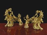 une paire de figurines anciennes en laiton posées sur une table en marbre rouge
