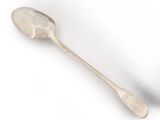 a silver spoon with a spoon handle on a white surface