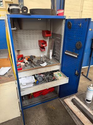 a blue cabinet with tools inside of it in a garage
