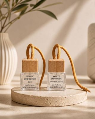 deux petits flacons de parfum posés sur une table, à côté d'une plante