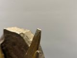 une statue représentant un homme tenant un marteau à côté d'un rocher