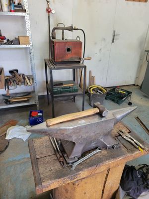 a table with an anvil on top of it in a garage