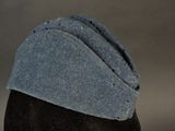 a black mannequin head with a blue hat on it