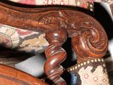 a close up of a wooden chair with a floral upholstered seat