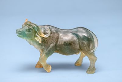 a glass figurine of an elephant on a blue background