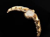 a close up of a gold wrist watch on a black background