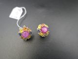 deux paires de boucles d'oreilles roses et jaunes posées sur un fond noir
