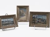 three framed pictures of boats and buildings on display on a white surface