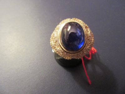 a picture of a ring with a blue stone on it