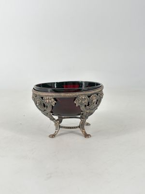 un plateau ancien en argent, muni d'un bol en verre rouge posé sur un socle