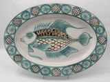a plate with a fish design on it on a stand