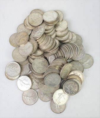 a pile of silver coins on a white surface