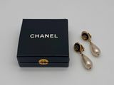 a pair of chanel earrings and a box on a table