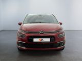 a red citrole parked in a room with a white wall