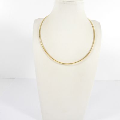 un mannequin blanc portant un collier en or