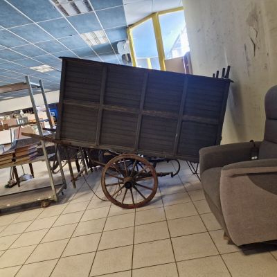 un canapé et un fauteuil dans une pièce où se trouve un chariot posé à même le sol