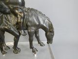 une statue en bronze représentant un garçon à cheval accompagné d'un chien