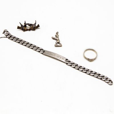 une photo représentant un bracelet, une bague et une boucle d'oreille posés sur une surface blanche