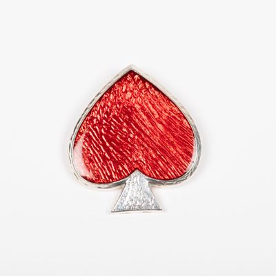 une broche représentant une couleur de jeu de cartes rouge et argentée sur un fond blanc