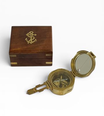 une vieille boussole en laiton dans un coffret en bois, sur fond blanc
