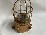 un vieux luminaire en laiton et en verre, surmonté d'un dôme en verre