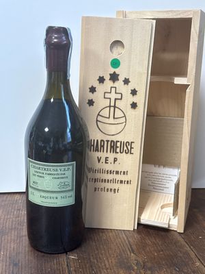 une bouteille de vin à côté d'une caisse en bois sur une table