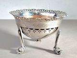 a silver bowl that is on a stand on a table