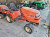 une tondeuse à gazon orange garée à côté d'autres tondeuses à gazon dans un garage