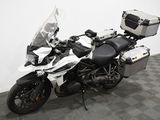 une moto qui est garée dans une pièce dont le sol est en damier