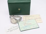a rolex wrist watch and a passport on a table