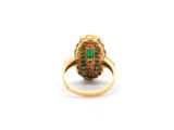 a close up of a gold ring with a green stone