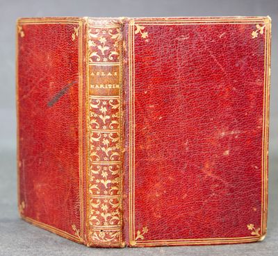 an old red book with gold trimming and gold trimming