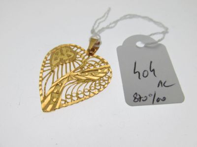 un pendentif en forme de cœur en or sur lequel est accrochée une étiquette de prix
