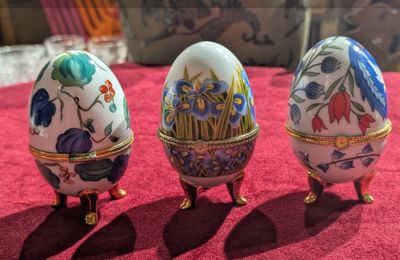 trois œufs décorés posés sur une nappe rouge