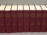 six livres rouges sont alignés sur une étagère
