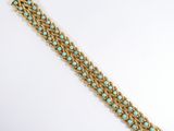 a close up of a gold bracelet with turquoise beads