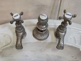 three faucets that are sitting on top of a sink