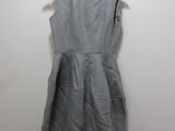 grey dress hanging on a hanger against a wall
