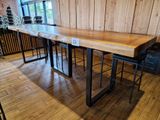 a large wooden table with two stools in front of it