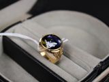 une bague en or sertie d'une pierre bleue, dans un écrin