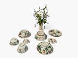 a vase with flowers in it sitting next to a set of dishes