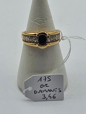 a gold ring with a black stone on top of it