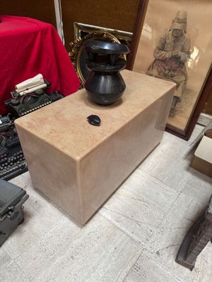 a black vase sitting on top of a wooden box