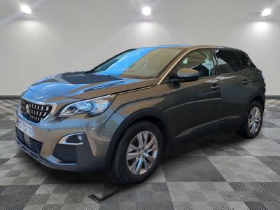 une voiture grise est garée dans une pièce au sol à carreaux