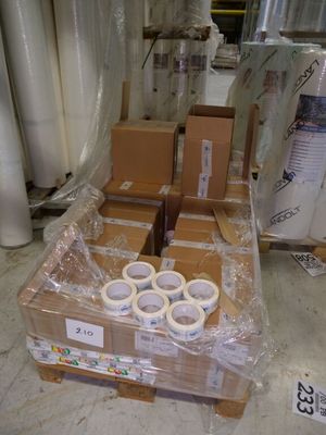 many rolls of tape sitting on a pallet in a warehouse