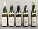 six bottles of wine are lined up on a table