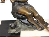 a statue of a woman sitting on a rock with a cat