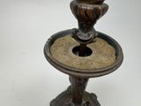a bronze candle holder on a pedestal with a white background
