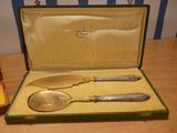 a silverware set in a green case on a wooden table