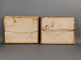 pair of antique wooden boxes with barbed wire on them on a gray surface